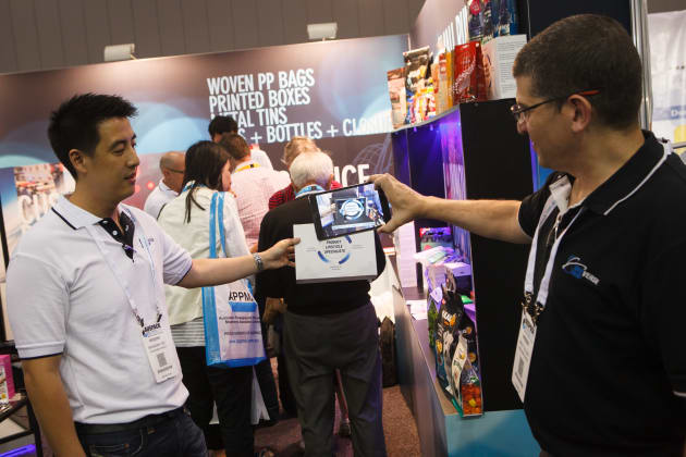 Brendan Yee (left), director of Omniverse Foster Group, demonstrates the company's AR technology, first launched at AUSPACK 2015.