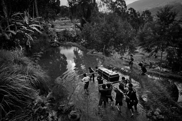 &copy; Alain Schroeder, Belgium. WINNER, TRAVEL PHOTOGRAPHER OF THE YEAR 2017. Sereale village, Toraja, Sulawesi Island, Indonesia. During a funeral ceremony a group of men carry the body around the property before the burial. The people are chanting and screaming pushing away any bad spirits.