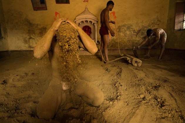 &copy; Alain Schroeder, Belgium. WINNER, TRAVEL PHOTOGRAPHER OF THE YEAR 2017. Varanasi, Uttar Pradesh, India. At the end of a workout, wrestlers are covering their heads and bodies with earth to soak up any perspiration and avoid catching cold.