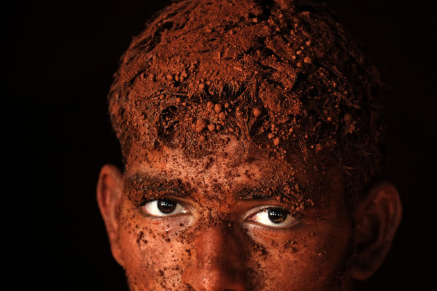 &copy; Alain Schroeder, Belgium. WINNER, TRAVEL PHOTOGRAPHER OF THE YEAR 2017. Kolhapur, Maharashtra State, India. Before every match, each wrestler covers the body of his adversary with this earth whose color varies by region (red in Kolhapur, yellow in Varanasi).