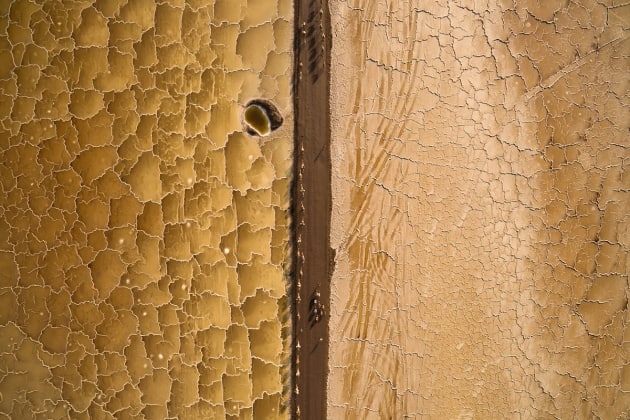 &copy; Joel Santos, Portugal. Winner, Travel Photographer of the
Year 2016. 
Salt Desert, Danakil Depression, Afar,
Ethiopia.
This unique aerial photo shows the salt
miners guiding a dromedary and donkey
caravan through this desert's unique salt
patterns.