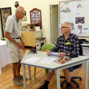 Alan Loxton (left) and Rick Harrison, competition committee members, man the fort during the judging. Name badges are de rigueur.
