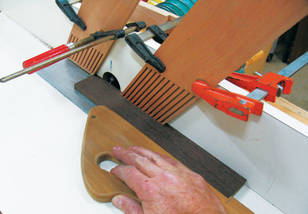 A pushstick used in conjunction with feather boards attached to the router table fence make the operation safe.