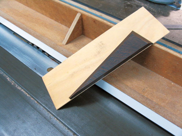 The angled box side shown cut and still attached to the straight edge. The straight pattern jig is shown still attached to the saw fence.