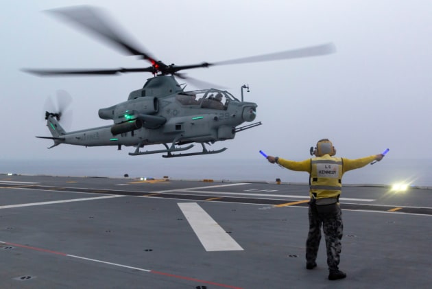 Leading Seaman Aviation Support Jamie Kennedy marshals a Marine Corps AH-1Z Viper helicopter aboard HMAS Adelaide.
Defence