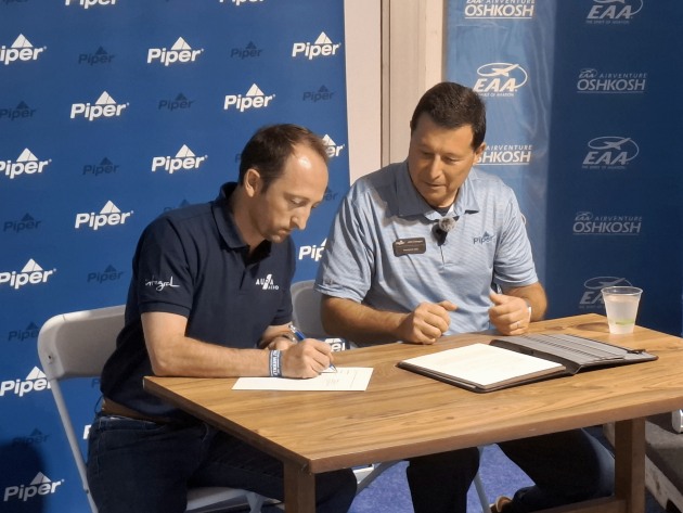 J&eacute;r&eacute;my Caussade, President and co-founder of AURA AERO, and John Calcagno, President and CEO of Piper Aircraft, sign MOU at EAA AirVenture Oshkosh 2026. (AURA AERO)