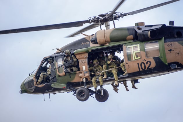 Soldiers from 2 Commando on board a 6th Aviation Regiment Black Hawk helicopter.
Defence