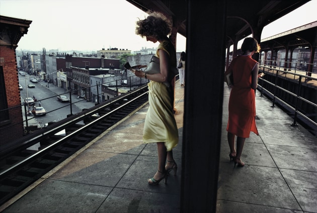Subway platform. New York City. USA.1980. &copy; Bruce Davidson / Magnum Photos. "I took this image on the elevated M Line at the Myrtle Avenue-Wyckoff Avenue stop in Bushwick, Brooklyn, as part of my Subway series. I saw this wonderful color-play between the two women &ndash; one wore a yellow dress with green shoes, the other was in red. As I was getting ready to click the shutter, the wind caught the dress of the women in yellow. It wasn't blowing it up around her knees like a Marilyn Monroe picture, it was just fluffing it. It was a delicate moment.&rdquo;
&ndash; Bruce Davidson