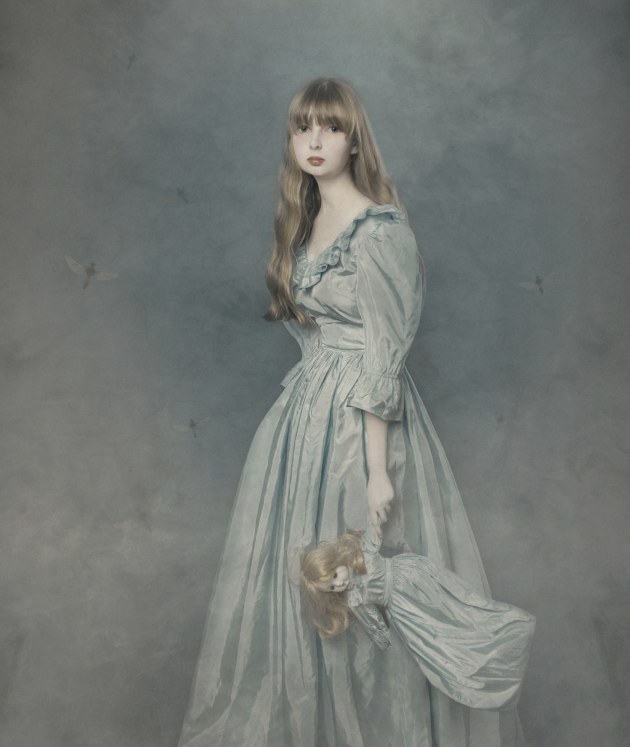 &copy; Naomi Bubner APP M.Photog. 2019 AIPP SA Portrait Photographer of the Year. Pretty dolly, with porcelain skin,
matching blue dresses, 
and golden straw fringe.
An old stone wall and fog so thick.
Her memories of childhood 
are carried away by dragonfly wings.