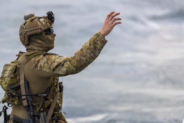A special forces soldier from 2nd Commando Regiment reaches out for the rope to support other soldiers fast-roping onto a Sydney ferry from an Army MRH-90 Taipan.
Defence