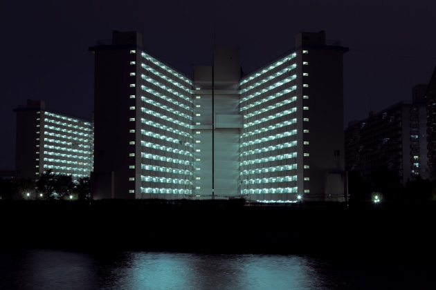 Toshima 5-chome Danchi. The illuminated form of a danchi across the Sumida River. &copy; Cody Ellingham.