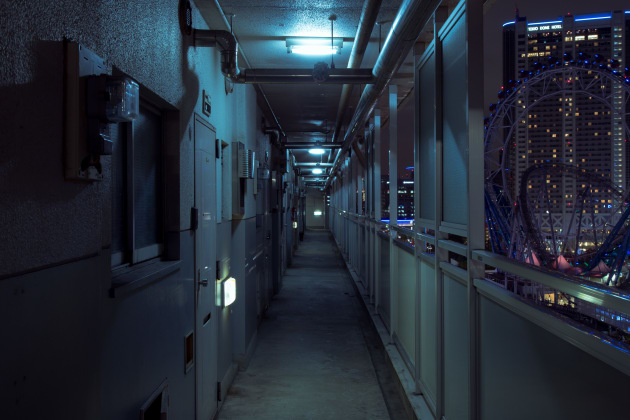 Toei Hongo 1-chome Apartment. The hyper-modern form of Tokyo Dome theme park contrasts with the harsh concrete hallway of a danchi. &copy; Cody Ellingham.