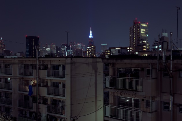 Aoyama Kitamachi Danchi. Silhouetted by the lights of the city, Aoyama Kitamachi Danchi was one of the first of its kind in Tokyo, located in the sought after shopping district of Aoyama. Redevelopment sealed its fate and the complex has been scheduled for demolition in 2019. &copy; Cody Ellingham.