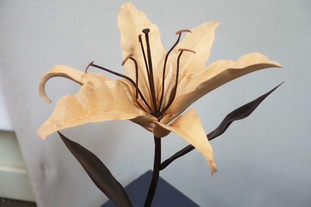 Dean Matthysen, Blooming Lily, paper bark. A lily in bloom carved from paper bark and ebonised timber flooring offcuts.