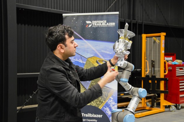 University of Adelaide researcher Mohsi Jawaid with an experimental satellite model attached to the orbital testbed's robotic arm.

Credit: Defence Trailblazer