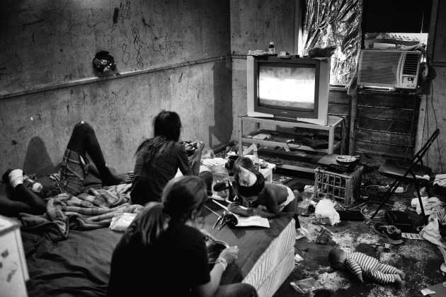 Liam, Charlette, Quane, Marjorie and Maagka  relaxing while watching TV in Charlette's room. Tourists fly in from all over the world to Broome to enjoy the Cable Beach resorts and the surrounding pristine environment, but for the residents of Kennedy Hill this reality is totally removed from their world. Broome, Western Australia. &copy; Ingetje Tadros/Diimex.