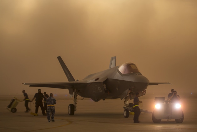 Lockheed Martin and Royal Australian Air Force maintenance personnel prepare to tow an Australian F-35A aircraft during a sudden dust storm at Luke Air Force Base, Arizona, USA. Defence