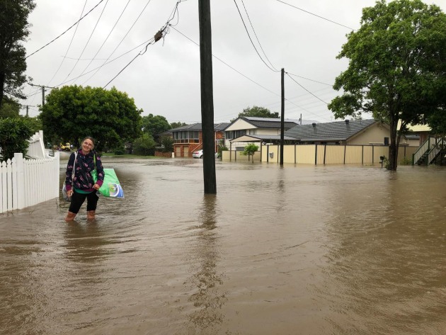 Nerida Kelton in the flooded street near her home and the AIP office.