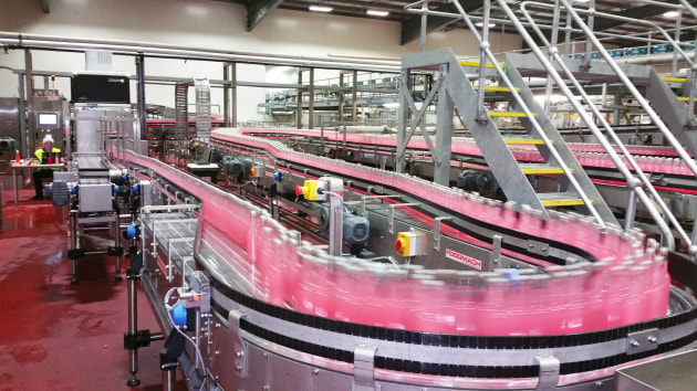 Foodmach conveying links third party bottle inspection systems together with fillers and labellers for a reduced-noise factory environment.