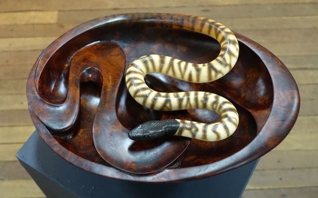 Gary Field and Lindsay Muir, Tension and Flow, red cedar, earthenware. "Desert to Rainforest: As artists we endeavour to reveal the tension, flow and diversity of the Australian landscape.
The rainforest being represented by the bowl carved from rare red cedar burl and the desert characterised in clay by the black headed python."