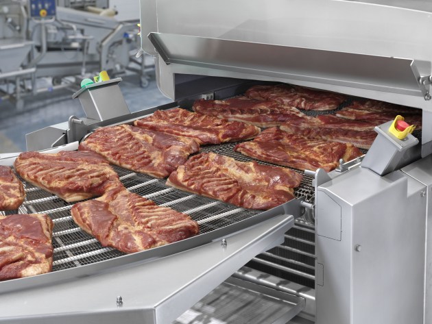 The GEA CookStar 1000 GEN 3 outfeed with smoked bacon bellies. Image: GEA