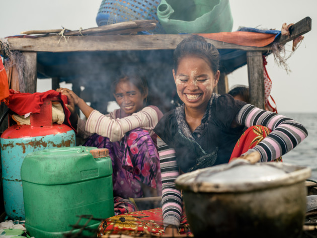 Riki cooking fish &lsquo;kupput&rsquo; on her family's Lepa Lepa. &copy; Mark Lehn.