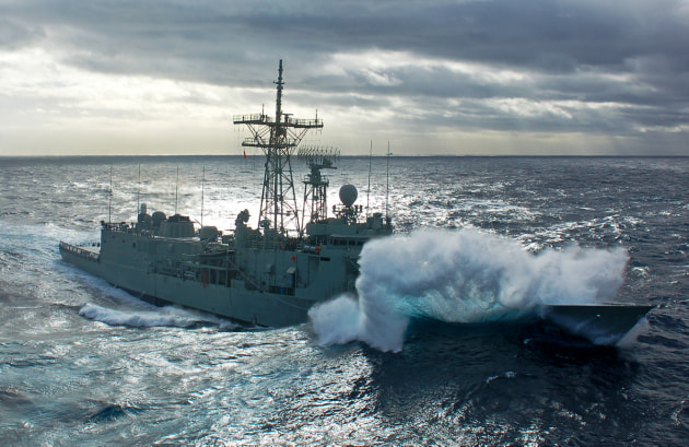 A 2013 photo of HMAS Melbourne as the crew prepares to connect fuel hoses with HMAS Sirius in a high sea state.
Defence