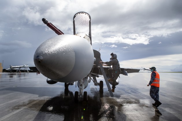 A pilot from No. 77 Squadron boards an F/A-18A Hornet A21-36 aircraft prior to an air-sea integration mission at Andersen Air Force Base.
Defence