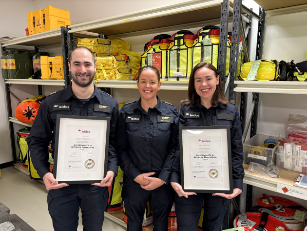 Two aircrew members with their qualifications, with Leidos Australia's RTO Compliance and Development Manager, Nicole Powell.

Credit: Leidos Australia