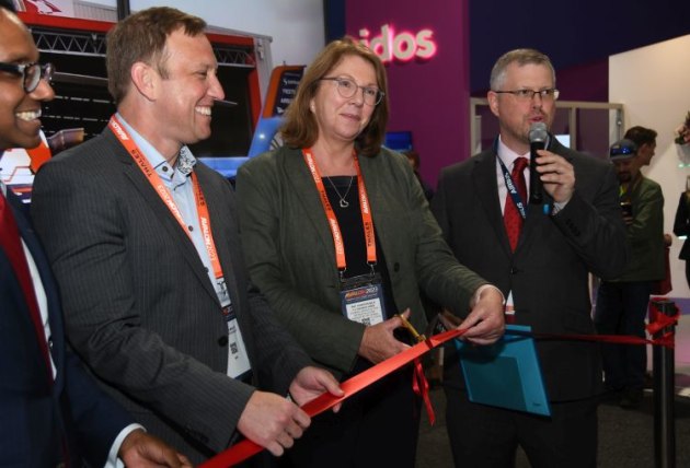 Minister for Infrastructure, Transport, Regional Development and Local Government Catherine King cuts a ribbon to celebrate the first flight in Australia of a helicopter running sustainable aviation fuel at Avalon 2023. (Steve Hitchen)