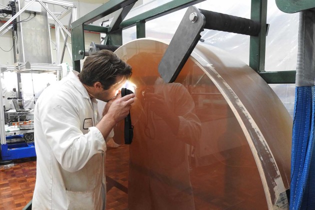 KSO technician inspecting the surface quality of a finished 1 metre optic. (Supplied)