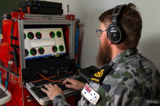 Petty Officer Aviation Technician Avionics Nicholas Simmons enters test flight data from an MH-60R helicopter into the computer.
Defence