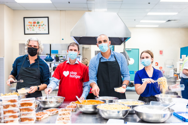 Bill Heague, Mars Food Australia General Manager; Geoff Webster, Sodexo General Manager of Strategic Accounts (centre); Andrew Borg, Mars Food Australia Supply Chain Director (right); and Jordynn Ardron, Foodbank NSW School Breakfast4Health and Agencies Coordinator, working together to prepare meals for families in need on the Central Coast. Source: Mars Food Australia