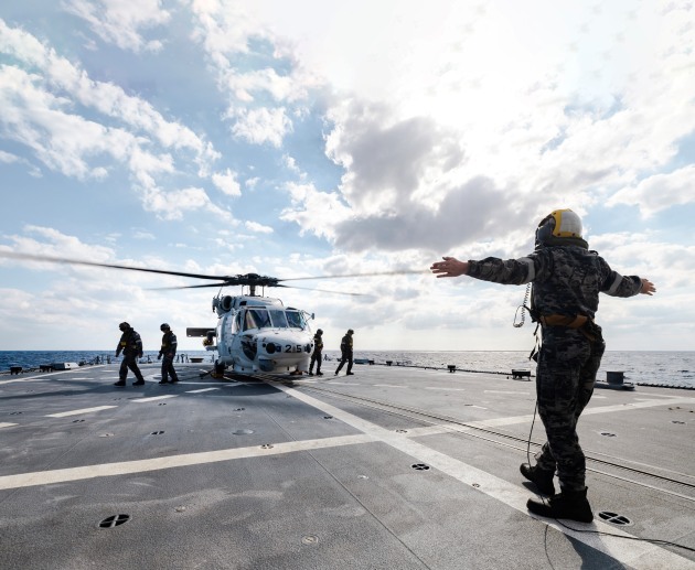 Personnel are guided from the JS Sazanami&rsquo;s embarked Super Auk helicopter as it prepares to take-off from HMAS Brisbane during a cross-deck in the Philippine Sea as part of Exercise Nichi Gou Trident 2023.

Credit: Defence