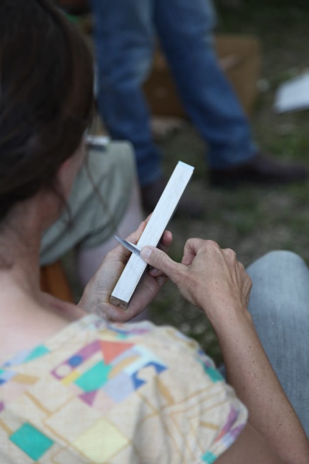 A new carver tries out her sharpening block, constructed during the sharpening workshop.