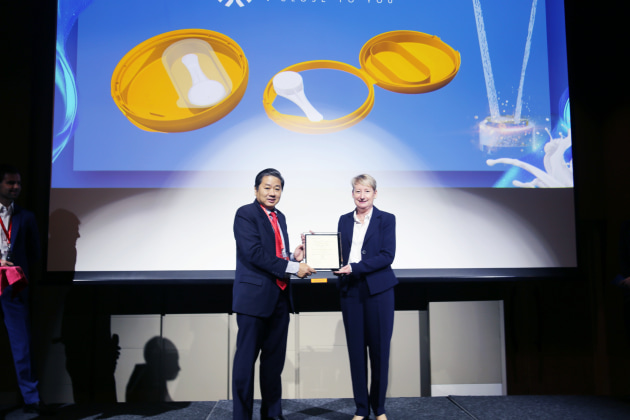 United Caps chief marketing and innovation officer Astrid Hoffmann-Leist accepts the award from Adhi Lukman. (Image: United Caps)