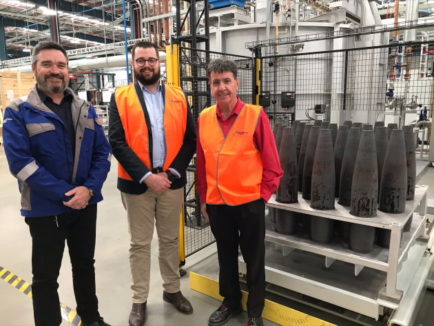 Rheinmetall NIOA Munitions project manager Jeff Crabtree, left, with RNM director Jackson Nioa and Member for Maryborough Bruce Saunders and the first projectiles to come out of the $60m shell forging plant in Marborough, Queensland. (Supplied)