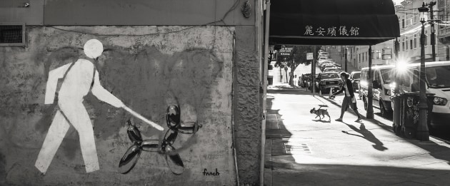 &copy; Kelly Champion APP AAIPP. 2019 AIPP SA Travel Photographer of the Year. San Francisco, September 2018. &ldquo;It sometimes takes a few days to get my 'eye in' while travelling, I look for potential scenes, especially those where lighting and shadows play and important role. 
While walking the streets of San Francisco I noticed the mural on the wall, which was signage for a dog day care centre. The back lit street scene was a perfect frame for me to wait for life to imitate the painting...&rdquo;