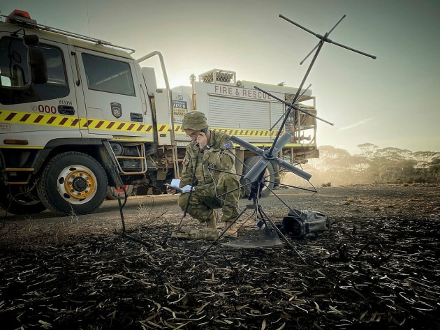 A soldier providing tactical satellite communications on fire grounds in Balladonia, WA. Defence
