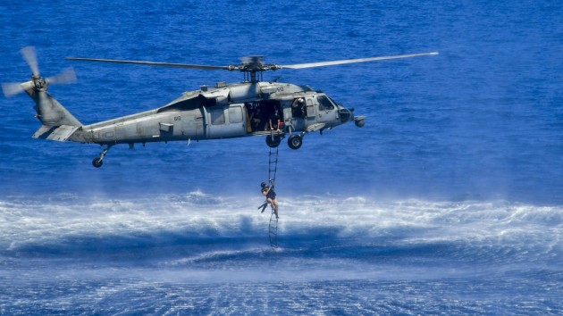A sailor climbs a rescue ladder attached up to an American MH-60S Seahawk helicopter during a training exercise in the Indian Ocean. Credit: Anthony J. Rivera via US Department of Defense