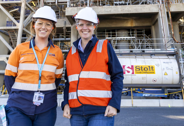 Viva Energy's New Fuels lead, Maddison McFadden and head of Future Fuels and Decarbonisation, Vanessa Lenihan, standing in front of Geelong Refinery's residue catalytic cracking unit, which will play an essential role in recycling plastic.