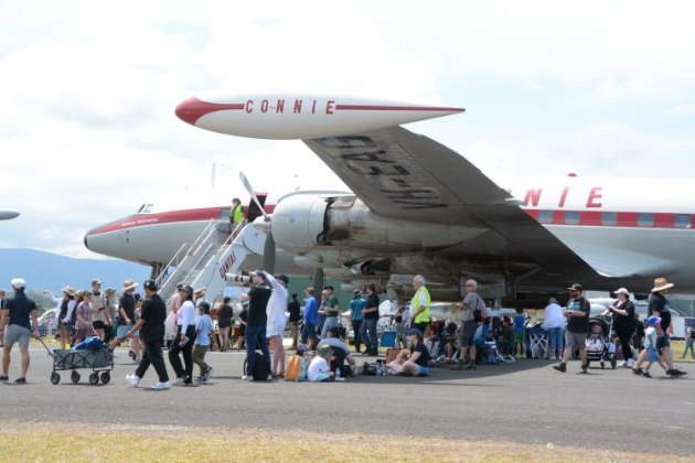 The bright sun sent some of the crowd seeking the shade of the big radials. (Steve Hitchen)