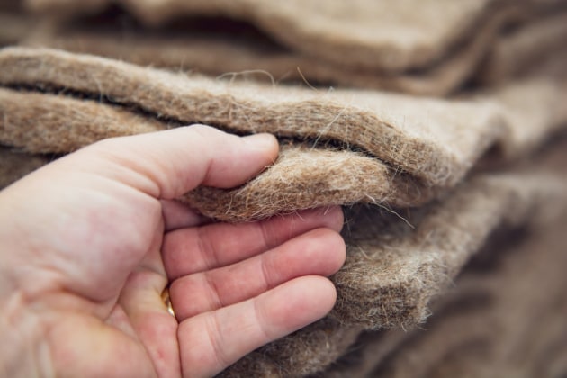 Waste wool destined for landfill is reprocessed and integrated into Woolpack packaging, forming a sustainable insulation layer.