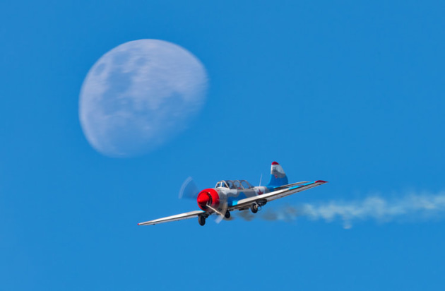 A Yak 52 is framed by the moon as it runs before the crowd line. (John Absolon)